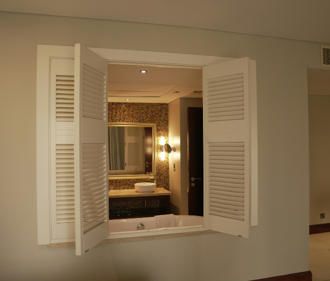 White bi-pass shutters on an internal window to a bathroom