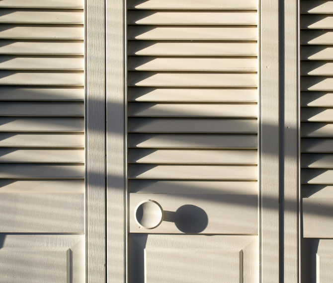A wardrobe with white shutter doors